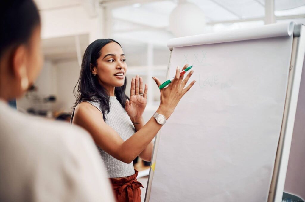female rd tax specialist presenting a flip chart to a colleague in a corporate office environment 
